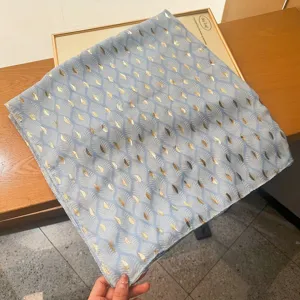 Lightweight blue shawl with elegant gold leaf print, perfect summer sun protection scarf accessory.