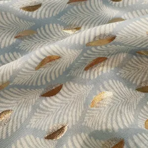 Detailed view of lightweight blue scarf fabric with metallic gold leaf pattern and soft sheer texture.