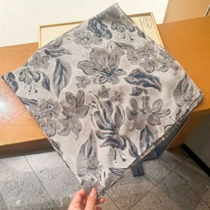 Detailed view of lightweight floral print scarf with shimmering glitter accents and soft texture.