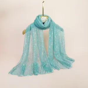Women shimmering sequin lightweight mesh scarf shawl in turquoise hanging on display.