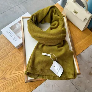 Detailed view of a cozy olive green knitted winter scarf, soft wool texture, unisex design.