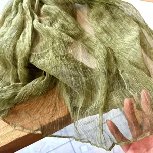 Close-up view of a sheer green crinkle nylon scarf, showing lightweight texture and fabric draping detail.