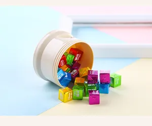 Detalle de dosificador de leche en polvo para bebe con cubitos de aperitivo coloridos.