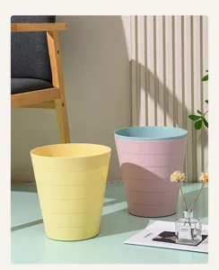 Papelera redonda de plástico minimalista con diseño acanalado, ideal para oficina y hogar.