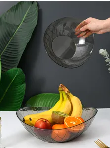 Détail de corbeille de fruits en plastique transparent, design grille grise moderne.