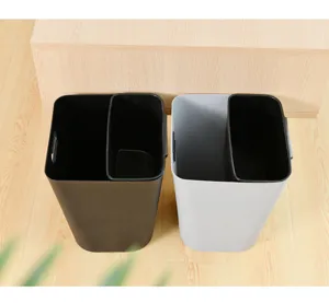 Detail view of household plastic trash can with dual compartments and lidless design.