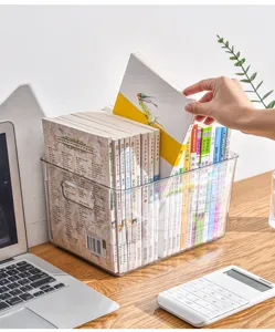 Detail de la boite de rangement transparente pour livres sur un bureau d'etudiant.