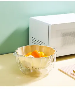 Vista di dettaglio di un cesto scolapiatti in plastica a doppio strato per frutta in cucina.