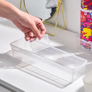 Clear plastic drawer organizer with adjustable dividers for makeup, cosmetics, and small items.