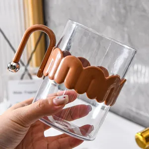 Clear glass mouthwash cup with stylish brown handle and wavy silicone sleeve for bathroom decor.