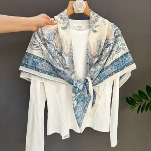 Elegante pañuelo cuadrado con estampado de cachemira azul con top blanco de manga larga.
