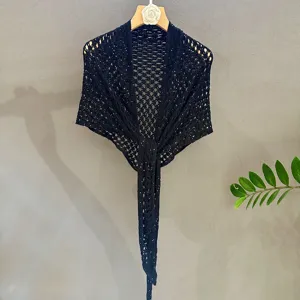 Black sequin knit shawl detail, openwork triangular scarf fabric and texture close up view.