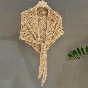 Detail shot of beige knitted sequin shawl, lightweight summer sun protection triangle scarf.