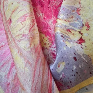 Detailed closeup view of a luxurious silk scarf showing vibrant abstract marble pattern.
