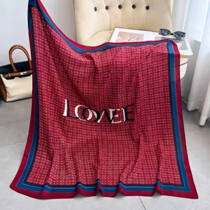 Nahaufnahme eines luxuriösen roten Seidenschals mit blauen Rändern und schicker LOVE-Typografie.