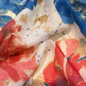 Nahaufnahme eines leichten Schals mit abstraktem Print, feiner Textur und bunten Farben.