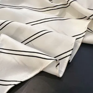 Closeup of white fabric with black double stripes, smooth texture, garment detail accessory shot.