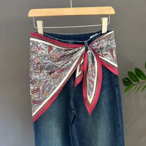 Stylish women denim jeans paired with trendy paisley print silk scarf, perfect daily wear.