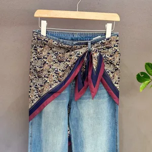 Denim jeans paired with paisley print square scarf tied at waist, fashionable wrap.