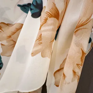 Close-up detail of lightweight summer floral shawl showing soft fabric drape and elegant print.