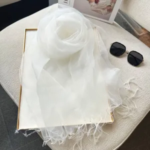 Elegant white sheer gauze tassel scarf detail, lightweight summer shawl accessory.