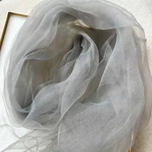 Detail shot of the elegant grey sheer mesh scarf, showcasing its lightweight and breathable texture.