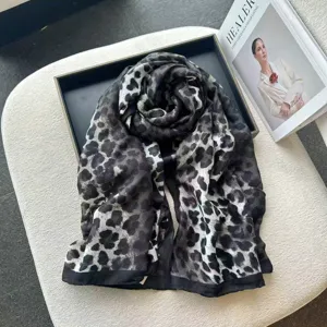 Detail shot of black and white leopard print linen scarf draped neatly in tray.