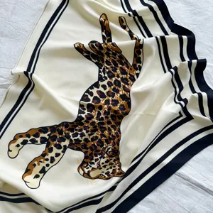 Detail view of luxury vintage leopard print silk scarf with classic striped border design.