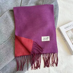 Detailed view of the dual-sided cashmere-feel scarf, featuring purple and red contrast and stylish fringes.