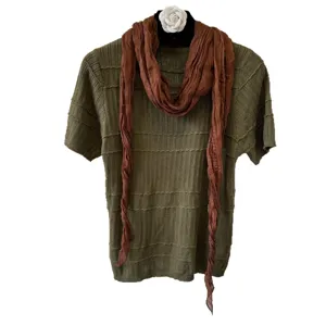 Green knit short sleeve top with brown scarf and floral brooch for women autumn wear.