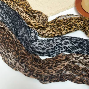 Detail view of fashionable lightweight leopard print crinkled scarves in various colors.