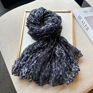 Detailed view of a stylish black and grey leopard print pleated scarf, elegant fashion accessory.