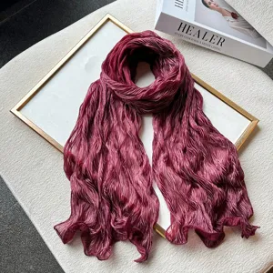 Detailed view of luxurious burgundy pleated long scarf, showcasing fine texture and soft fabric.