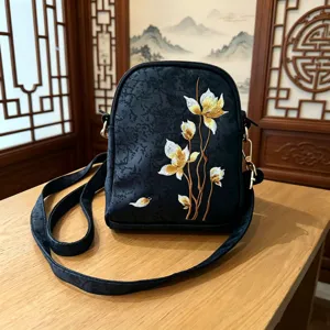 Elegant black crossbody bag with traditional Chinese floral embroidery and gold hardware.