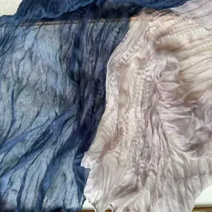 Close-up detail of lightweight crinkled fabric featuring double color drape texture style.
