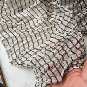 Detailed close-up view of the women pleated checkered scarf fabric texture and pattern design.