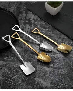 Detalle de la cuchara en forma de pala de acero inoxidable con acabado en oro y plata.