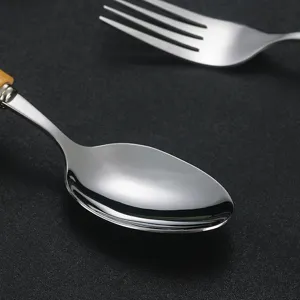 Stainless steel spoon and fork set with wooden handle for western dining kitchen tableware.
