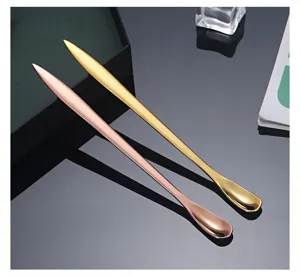 Close-up detail of long stainless steel tea spoon and coffee knife spoon in gold and rose gold finishes.
