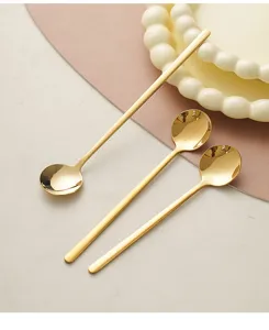 Close-up detail of luxury golden stainless steel spoons on elegant decorative tableware.