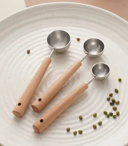 Stainless steel measuring spoons with wooden handles, ideal for kitchen baking and coffee beans.