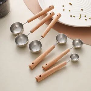 Set of stainless steel measuring spoons with wooden handle for kitchen baking coffee beans.