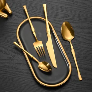 Gold stainless steel flatware set with black tray, 4-piece modern cutlery for dining table.