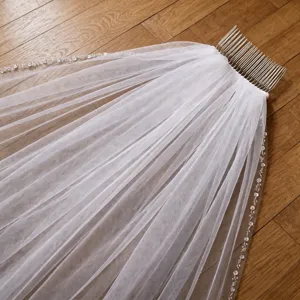Velo da sposa bianco con pettine in metallo e bordo perlinato, dettaglio accessorio matrimonio.