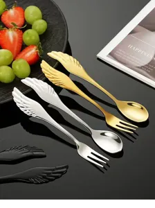 Detailed view of stainless steel angel wing shaped dessert spoon and fruit fork tableware.