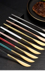 Stainless steel steak knife detail, elegant multi-color handle design, luxury table setting.