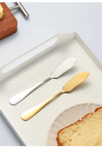 Stainless steel butter knife detail shot, silver and gold spreader tool for jam, cheese, bread.