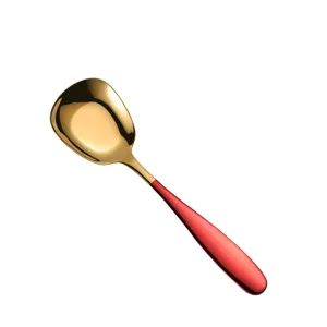 Stainless steel flat bottom spoon with gold head and red handle for kitchen dining table.