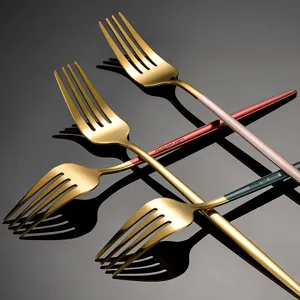 Stainless steel western cutlery fork set with gold head and colorful handles for dining.