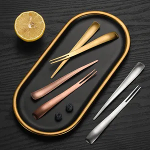 Stainless steel dual-purpose fork and spoon set with golden tray for fruit and dessert.